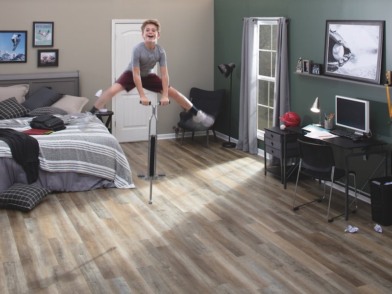 child on pogo stick in bedroom with hardwood floors