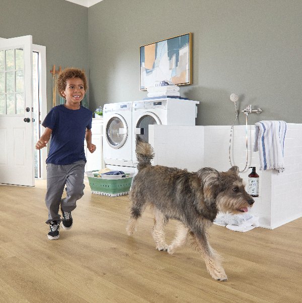 Child running with dog indoors on durable Pergo floors